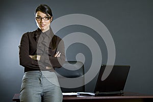 Attractive businesswoman against office desk