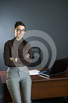 Attractive businesswoman against office desk