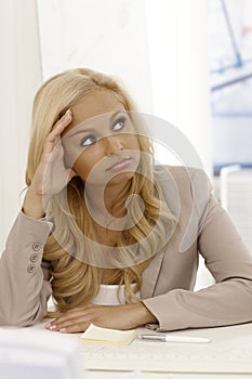 Attractive businesswoman daydreaming at desk