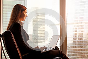 Attractive businesswoman enjoying sunset, relaxing in office cha