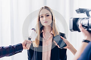 Attractive businesswoman giving interview to journalists