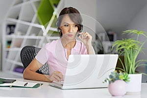 Attractive businesswoman having online meeting while sitting behind her laptop at office desk