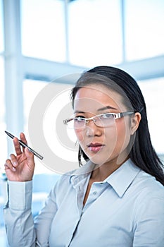 Attractive businesswoman holding pen