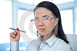 Attractive businesswoman holding pen