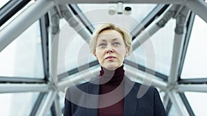 Attractive businesswoman looking at camera outside while working at modern business center. She is wearing formal