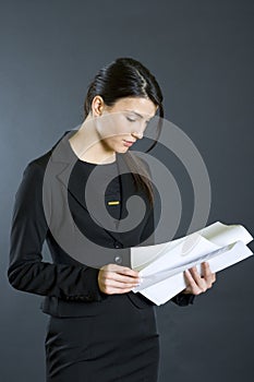 Attractive businesswoman reading papers