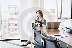 Attractive businesswoman relaxing in a modern office while on coffee break