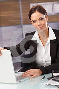 Attractive businesswoman shutting down laptop photo