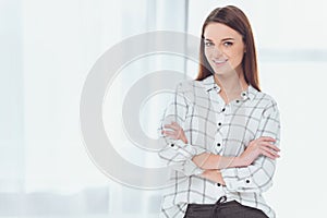 attractive businesswoman standing with crossed hands and looking