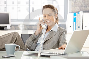 Attractive businesswoman talking on phone smiling