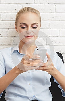 Attractive businesswoman texting on her mobilephone