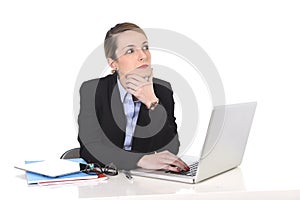 Attractive businesswoman thinking and looking distraught while working on computer photo