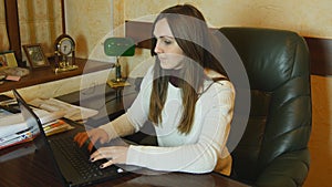 Attractive businesswoman working late at night on laptop at office