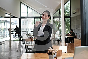 Attractive businesswomen standing and smiling at camera.