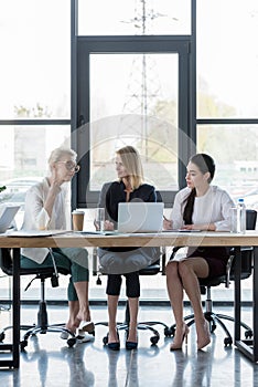 attractive businesswomen using laptop at meeting