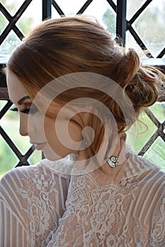 Attractive busty redhead model dressed in lace in an old house in England