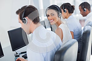 Attractive call centre employee looking over shoulder