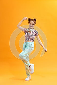 Attractive careless cheerful girl jumping listening bass having fun isolated over bright yellow color background