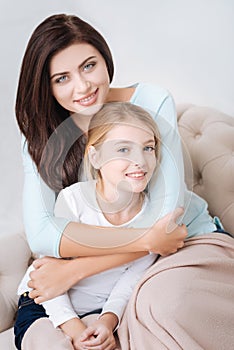 Attractive caring mother hugging her daughter