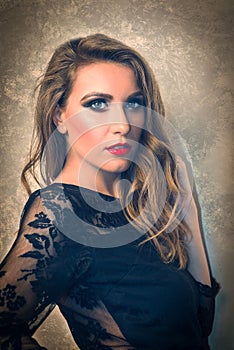 Attractive Caucasian Blonde Portrait with Black Lace Top and Wavy Hair, on Golden Background