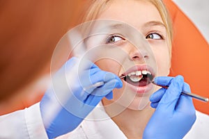 attractive caucasian child visiting dentist, doctor doing dental examination