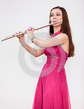 Attractive Caucasian woman a flutist playing on silver flute