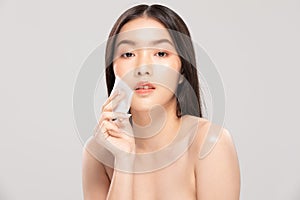Attractive Charming Asian young woman smile and using tissue with toner for cleaning make up feeling so fresh and clean with