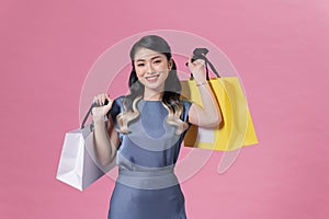 Attractive cheerful girl holding buyings consumerism isolated over pink color background photo