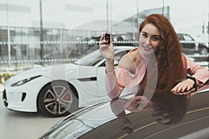 Happy woman holding car keys to her new automobile