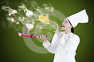Attractive chef cooking with magic