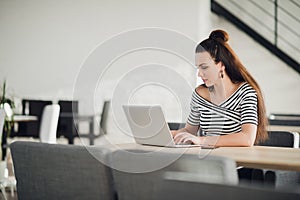 Attractive concentrated adult woman browsing the internet and searching information for business during lunchtime.