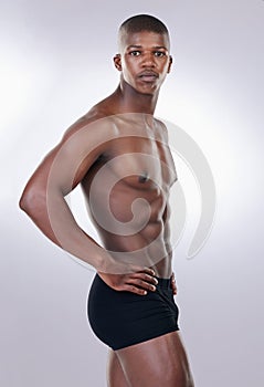 Attractive, confidence and portrait of a shirtless man in a studio with a muscular body in underwear. Serious, fitness