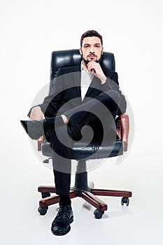 Attractive confident young bearded businessman sitting in office chair