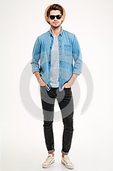 Attractive confident young man standing with hands in pockets