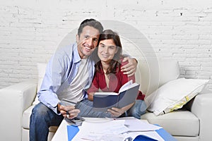 Attractive couple accounting debt at home couch happy in financial success and wealth