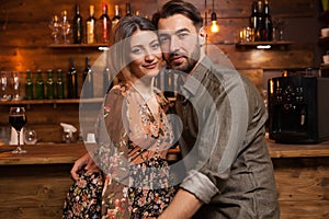 Attractive couple celebrating their aniversary and looking at the camera in vintage pub