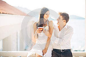 Attractive couple drinking cocktails ,enjoying summer vacation.Smiling,attracted to each other.Flirting and seduction