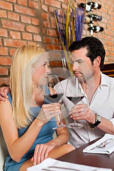 Attractive couple drinking red wine in restaurant