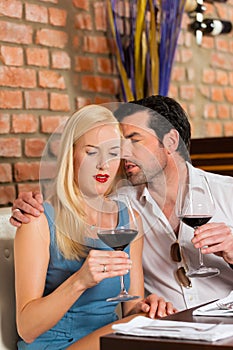 Attractive couple drinking red wine in restaurant