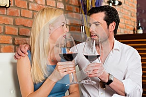 Attractive couple drinking red wine in restaurant or bar