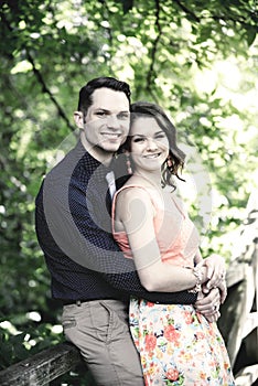 Attractive couple embracing on a bridge