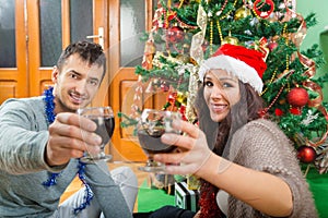 Attractive couple enjoying Christmas time drinking wine celebrating