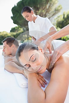 Attractive couple enjoying couples massage poolside