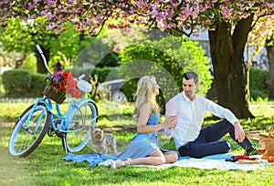 Attractive Couple Enjoying Romantic Sunset Picnic in Countryside. Romance concept. Inspiring feelings. Cheers. Celebrate