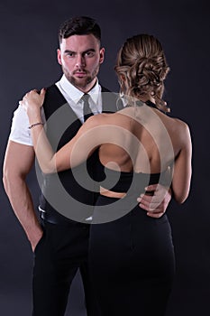 Attractive couple in formal attire on black background