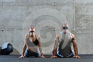 An attractive couple in the gym engaging in various stretching exercises together, showcasing their dedication to