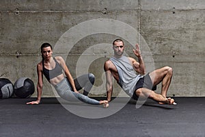 An attractive couple in the gym engaging in various stretching exercises together, showcasing their dedication to