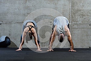 An attractive couple in the gym engaging in various stretching exercises together, showcasing their dedication to