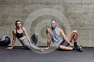 An attractive couple in the gym engaging in various stretching exercises together, showcasing their dedication to