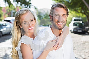 Attractive couple hugging each other and smiling at camera